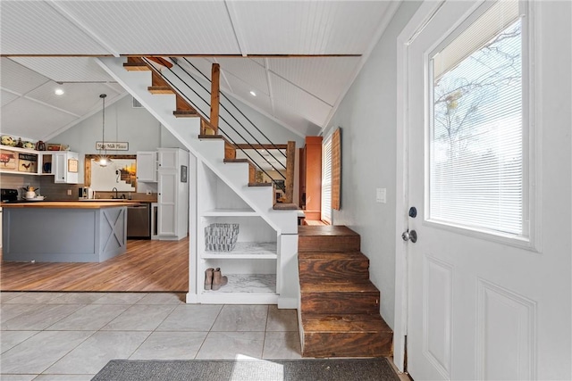 stairway with lofted ceiling and tile patterned floors