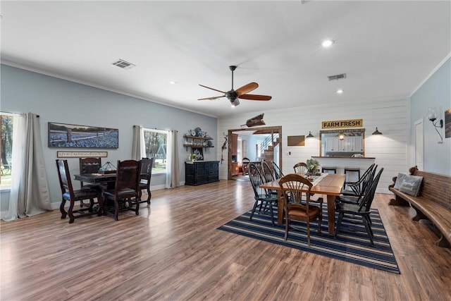 dining room with stairway, visible vents, wood finished floors, and ornamental molding