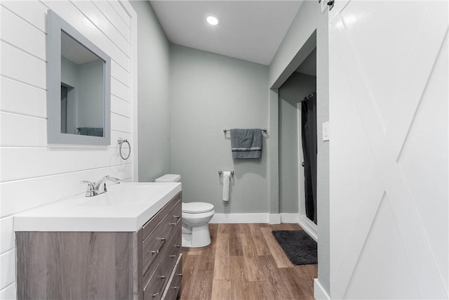 full bath with baseboards, toilet, a shower with curtain, wood finished floors, and vanity