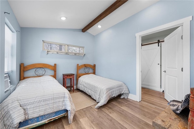 bedroom featuring lofted ceiling with beams, a barn door, light wood-style flooring, and recessed lighting