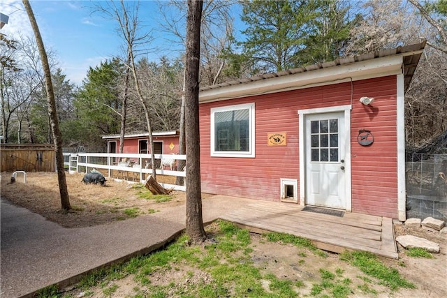 view of outdoor structure featuring fence and an outbuilding