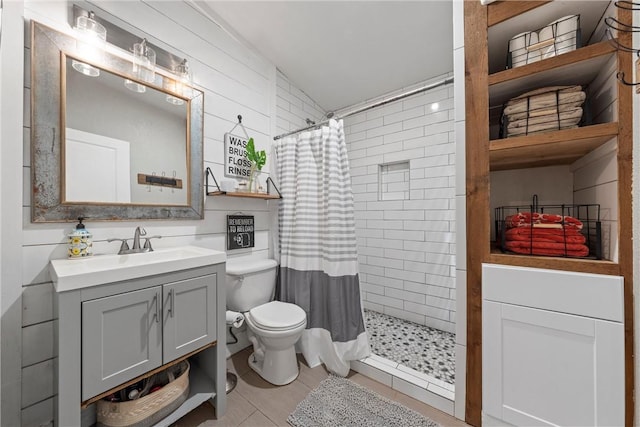 bathroom featuring toilet, tiled shower, and vanity