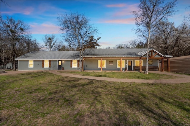 single story home featuring a front yard and metal roof