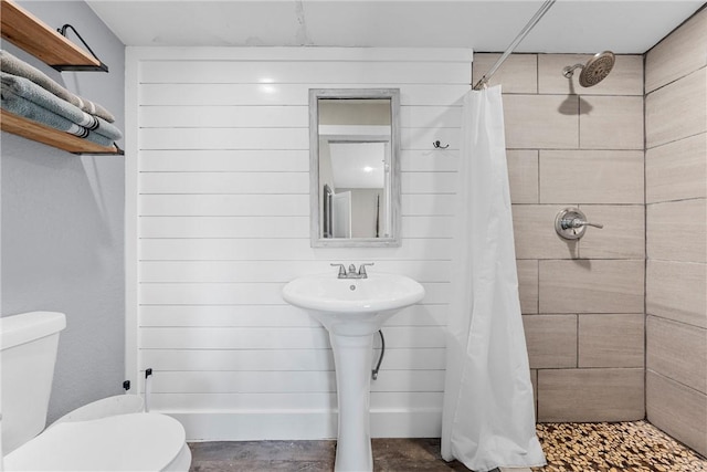 bathroom featuring a tile shower and toilet