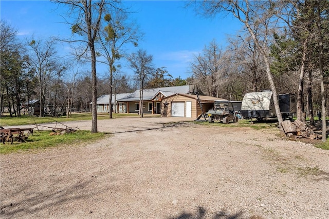 view of front of property with a garage and dirt driveway