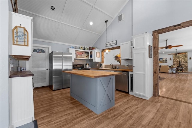 kitchen with visible vents, appliances with stainless steel finishes, white cabinetry, a sink, and wood counters