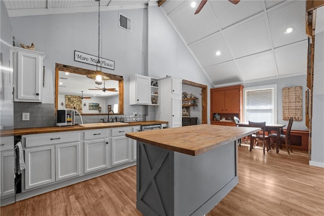 kitchen featuring light wood-type flooring, visible vents, wooden counters, and ceiling fan