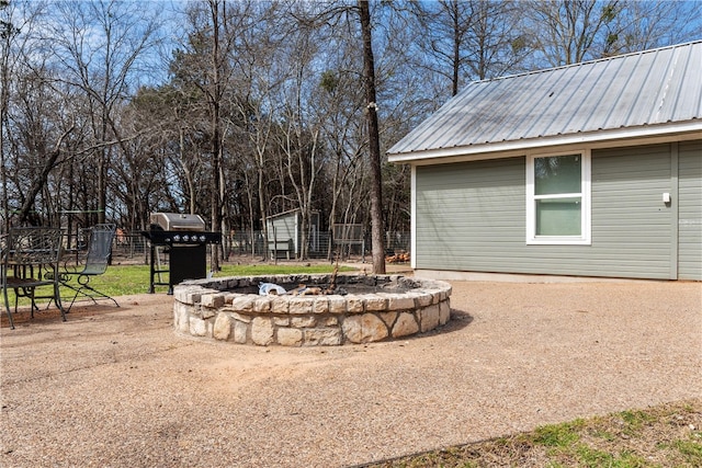 view of yard featuring an outbuilding, a patio, an outdoor fire pit, fence, and driveway