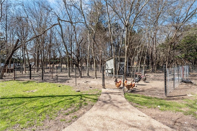 view of yard featuring exterior structure, fence, and an outdoor structure