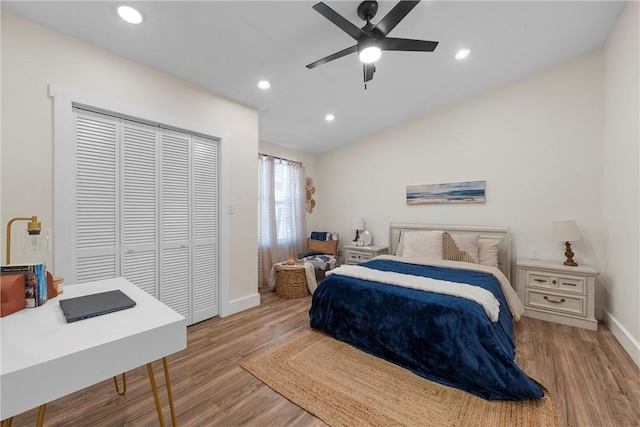 bedroom featuring lofted ceiling, a closet, recessed lighting, and wood finished floors