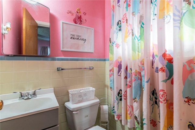 bathroom with vanity, curtained shower, toilet, and tile walls