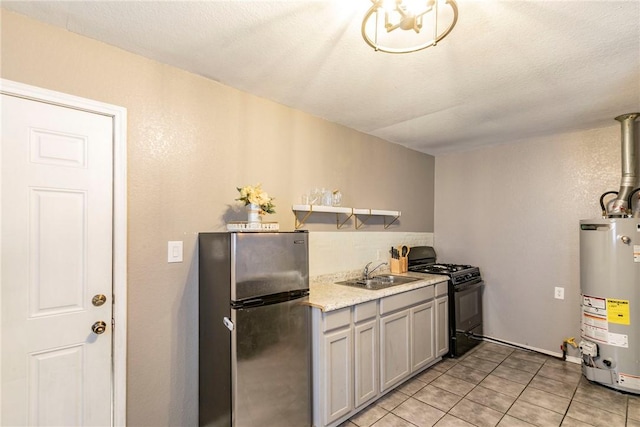 kitchen featuring gray cabinetry, black gas range, gas water heater, sink, and stainless steel fridge