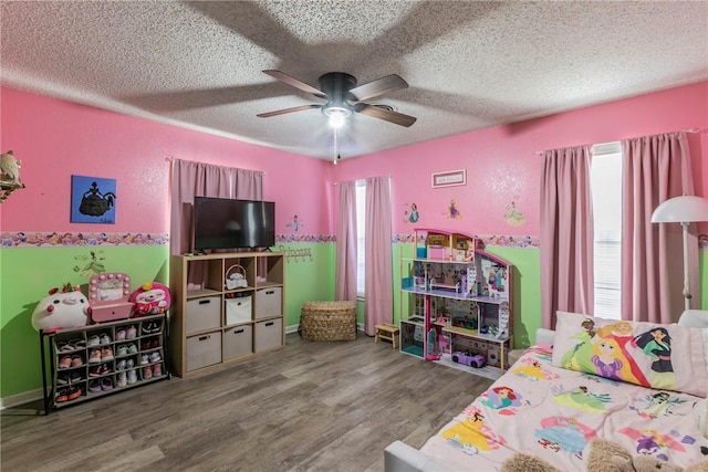 bedroom featuring hardwood / wood-style flooring, ceiling fan, and a textured ceiling