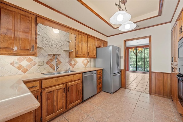 kitchen with decorative light fixtures, sink, stainless steel appliances, and an inviting chandelier