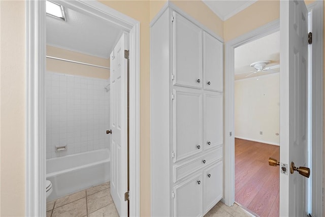 bathroom featuring crown molding, toilet, wood-type flooring, and tiled shower / bath