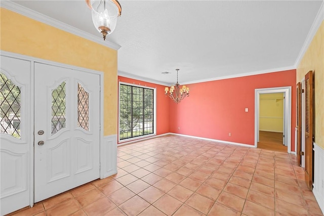 tiled foyer entrance with crown molding and a notable chandelier