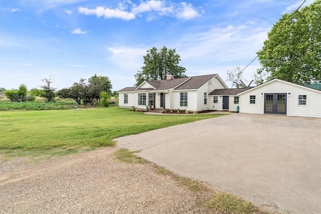 ranch-style home featuring french doors and a front yard