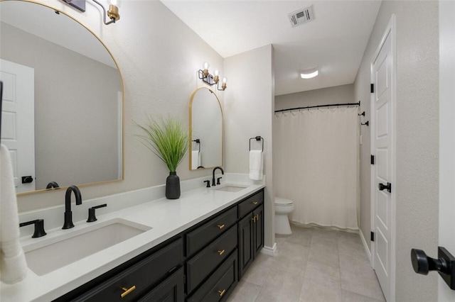 bathroom featuring tile patterned flooring, vanity, and toilet