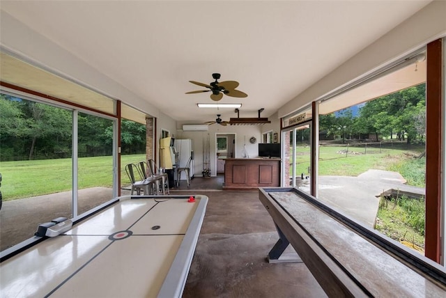 unfurnished sunroom featuring a wall mounted air conditioner and ceiling fan