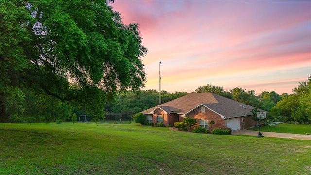 ranch-style home with a lawn and a garage