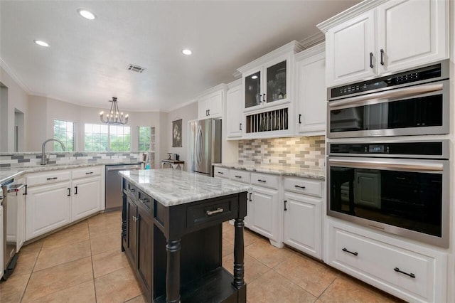 kitchen featuring pendant lighting, light tile patterned floors, white cabinetry, stainless steel appliances, and a chandelier