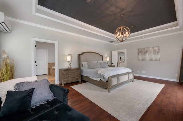 bedroom with a wall mounted air conditioner, dark hardwood / wood-style flooring, a notable chandelier, ensuite bathroom, and a tray ceiling