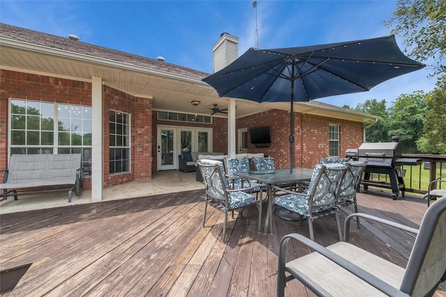 wooden terrace with ceiling fan and a grill