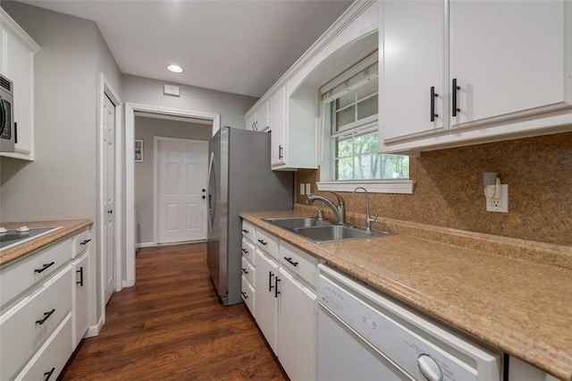 kitchen with white cabinetry, sink, dark hardwood / wood-style flooring, decorative backsplash, and appliances with stainless steel finishes