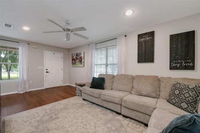 living room featuring wood-type flooring and ceiling fan