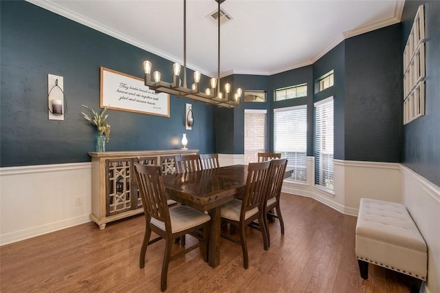 dining area featuring hardwood / wood-style flooring, crown molding, and radiator