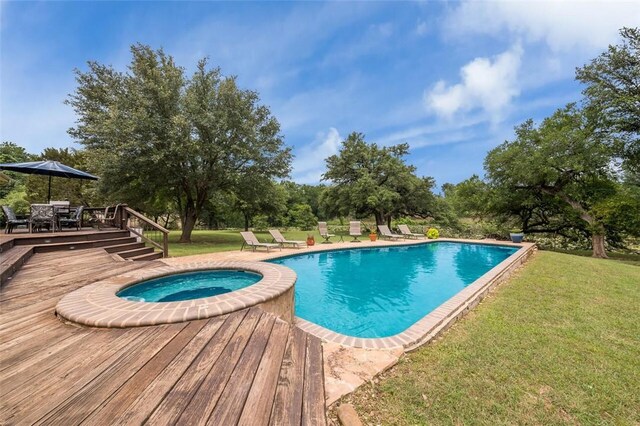 view of pool featuring an in ground hot tub, a deck, and a lawn