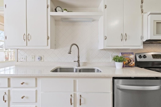 kitchen featuring white cabinetry, decorative backsplash, appliances with stainless steel finishes, and a sink