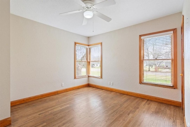 unfurnished room featuring baseboards, wood finished floors, and a ceiling fan