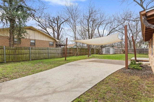 view of yard featuring a storage unit, a patio, an outbuilding, and a fenced backyard