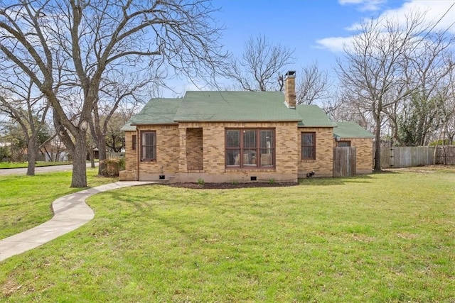 back of house featuring fence, a yard, crawl space, brick siding, and a chimney