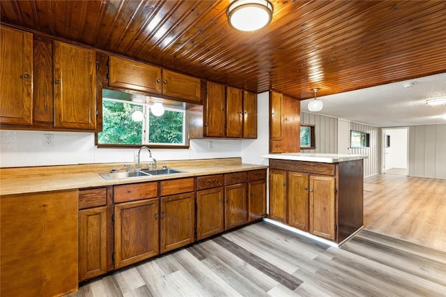 kitchen with wooden ceiling, sink, decorative light fixtures, light hardwood / wood-style floors, and kitchen peninsula