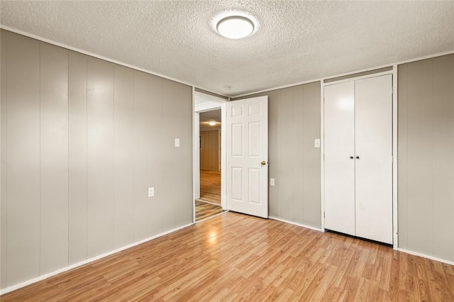 unfurnished bedroom with light hardwood / wood-style floors and a textured ceiling