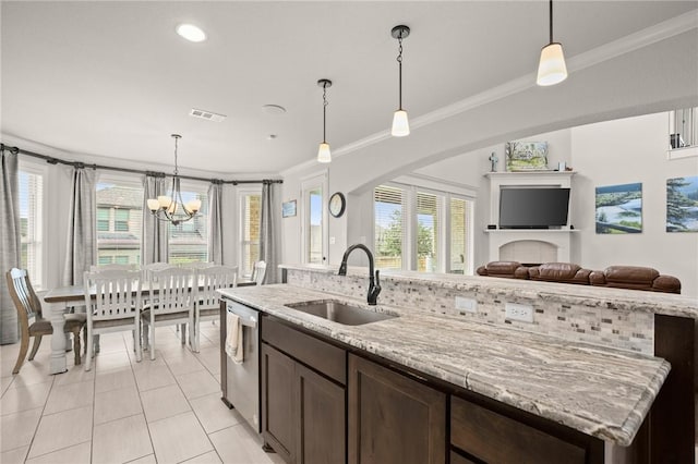 kitchen featuring a sink, visible vents, dark brown cabinets, dishwasher, and an island with sink