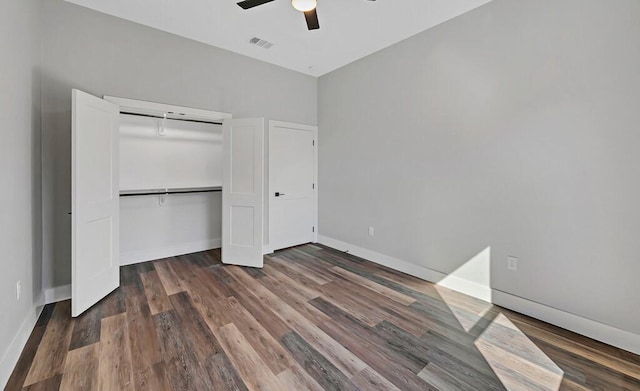 unfurnished bedroom with ceiling fan, dark hardwood / wood-style floors, and a closet