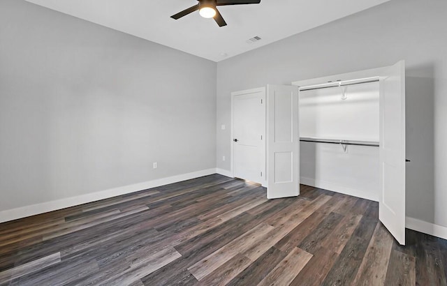 unfurnished bedroom with dark hardwood / wood-style flooring, a closet, and ceiling fan