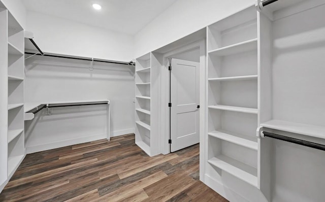 walk in closet with an AC wall unit and dark hardwood / wood-style floors