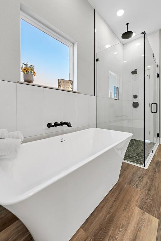 bathroom with hardwood / wood-style flooring and separate shower and tub