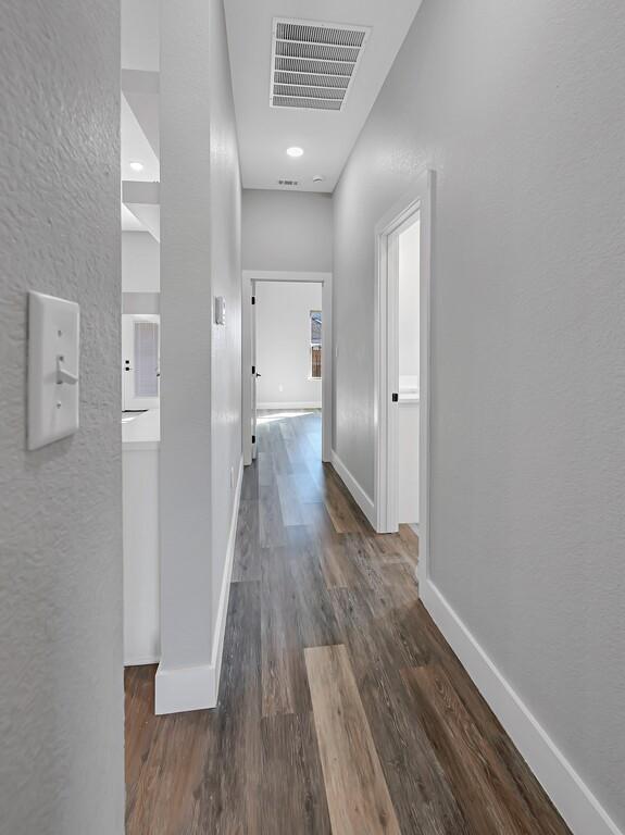 corridor with dark hardwood / wood-style flooring