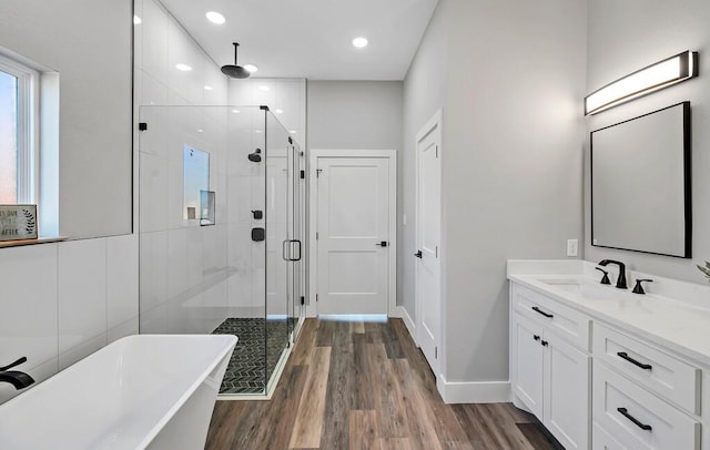 bathroom with hardwood / wood-style floors, vanity, and independent shower and bath