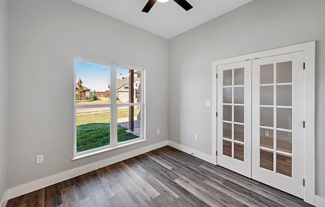 empty room with dark hardwood / wood-style floors, ceiling fan, and french doors