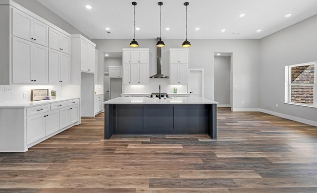 kitchen featuring dark hardwood / wood-style floors, white cabinetry, hanging light fixtures, and wall chimney range hood