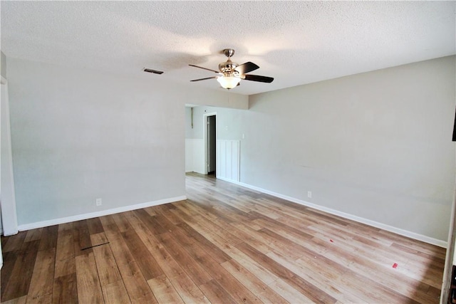 unfurnished room featuring a textured ceiling, light hardwood / wood-style flooring, and ceiling fan