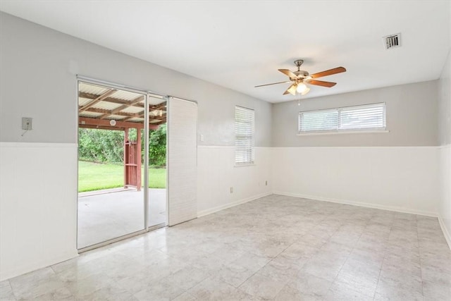 unfurnished room featuring ceiling fan and a wealth of natural light