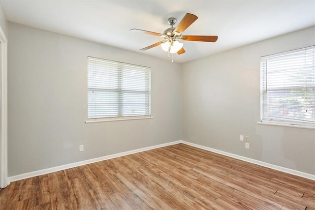 empty room featuring light wood-type flooring, plenty of natural light, and ceiling fan