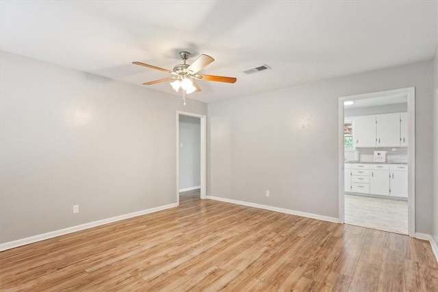 unfurnished room with light wood-type flooring and ceiling fan